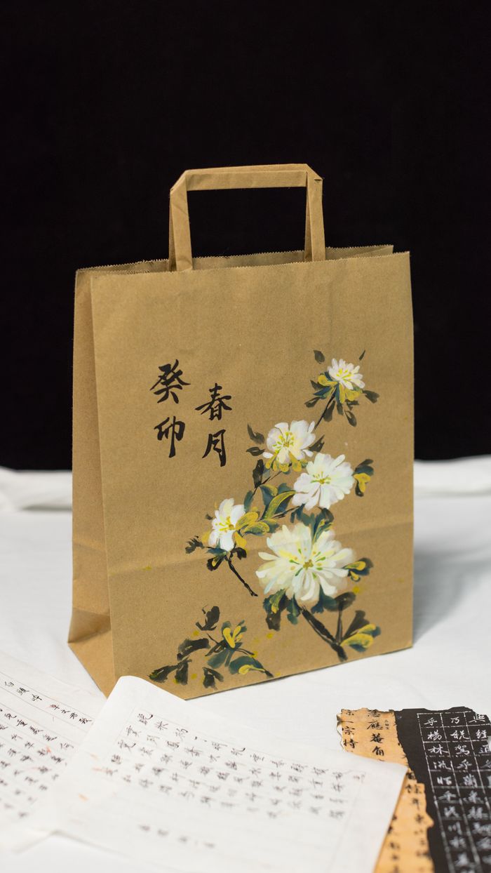services-04 Brown paper bag with floral artwork and Chinese calligraphy, shot indoors.